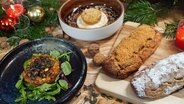 Quarkstollen, Muffin und Kürbis-Törtchen auf einer weihnachtlich dekorierten Arbeitsplatte. © NDR Foto: Tarik Rose