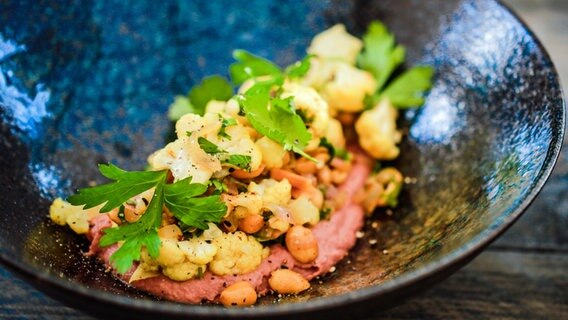 Blumenkohlsalat mit Rote-Bete-Hummus auf einem Teller angerichtet © NDR Foto: Tarik Rose