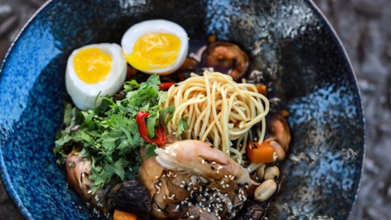 Ramen-Suppe mit Grünkohl und Ei in einer dunklen Schüssel serviert. © NDR Foto: Tarik Rose