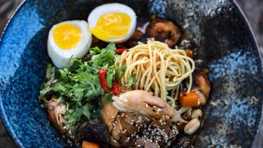 Ramen-Suppe mit Grünkohl und Ei in einer dunklen Schüssel serviert. © NDR Foto: Tarik Rose