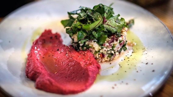 Rote-Bete-Hummus mit Blumenkohlsalat auf einem Teller serviert. © NDR Foto: Tarik Rose