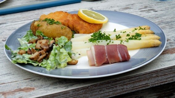 Stangenspargel mit paniertem Kalbsschnitzel, Katenschinken, Kartoffeln und Römersalat angerichtet © NDR Foto: Tarik Rose