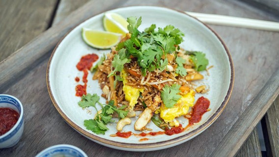 Nasi Goreng mit Rührei und Tofu auf einem Teller angerichtet. © NDR Foto: Tarik Rose