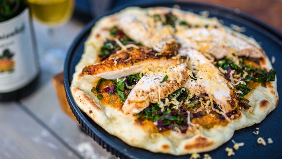 Pfannenpizza mit Ofenhuhn auf einem Teller serviert. © NDR/nonfictionplanet Foto: Tarik Rose