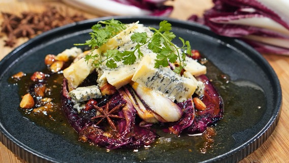Braised radicchio with walnuts, orange and blue cheese served on a plate.  © NDR Photo: Florian Kruck