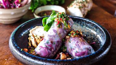 Rotkohl-Sommerrollen und gegrillter Ziegenkäse in einer runden Schale auf einem Holztisch serviert. © NDR Foto: Tarik Rose