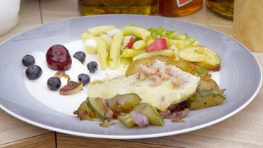 Überbackenes Schollenfilet mit Krabben, Ofenkartoffeln und Schmorgurke angerichtet © NDR Foto: Tarik Rose