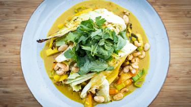 Geschmorter Ofen-Spitzkohl mit Gemüse-Curry auf einem Teller serviert. © NDR Foto: Tarik Rose