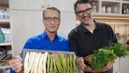 dr Matthias Riedl and Tarik Rose hold a box of asparagus for the camera.  © NDR/dmfilm/Florian Kruck 