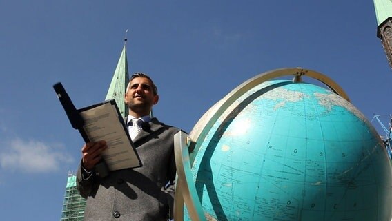 Michel Abdollahi mit einem Riesen-Globus. © NDR 