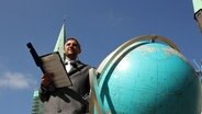 Michel Abdollahi mit einem Riesen-Globus. © NDR 