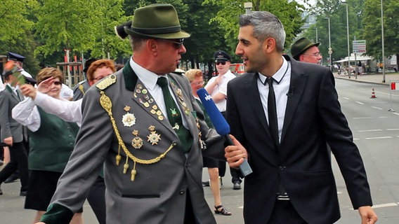 Michel Abdollahi im Gespräch mit einem Schützen bei der Schützenparade in Hannover. © NDR 