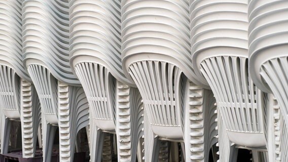 Weiße Plastikstühle stehen aufeinander gestapelt © imago stock&people 