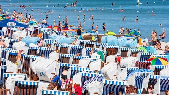 Ein Strand mit vielen Besuchern, Strandkörben und Sonnenschirmen © mauritius images / Volker Preusser / 