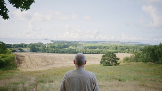 Ein Mann blickt über einen Hügel in die Ferne © NDR Fernsehen 