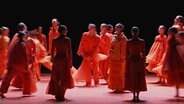 Tänzer in roter Kleidung bewegen sich auf der Bühne © NDR.de 