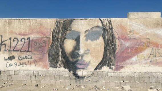 Bild eines Frauenkopfes auf einer Mauer in Katar. © NDR 