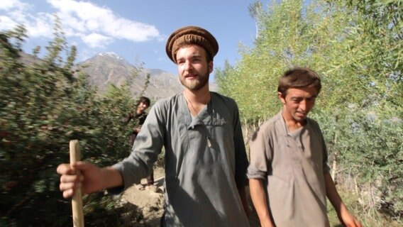 Filmemacher Samuel Häde wird von seinem Gastgeber Ayunbek aus dem Dorf eskortiert. © NDR 