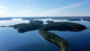 Ein Wallberg ist ein langgestreckter Hügelrücken aus der Eiszeit. Der Wallberg von Punkaharju führt mitten durch den See und gehört zu den Naturdenkmälern Finnlands. © NDR/Florianfilm GmbH 