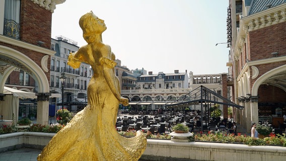 Eine goldene Frauenfigur auf einem Platz in der Stadt Batumi. © NDR/Vincent TV/Steven Galling 
