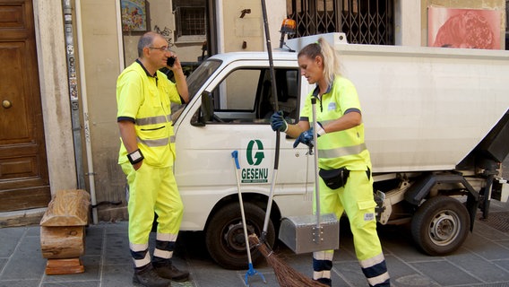 Steile Treppe, enge Gassen. In Perugia muss die Strassenreinigung mit dem Handbesen erfolgen. Lando Morganti (links) und seine Kollegin sind im Dauereinsatz, damit Perugia rund um die Uhr gepflegt aussieht. © NDR/Casei Media GmbH/Milena Schwoge 