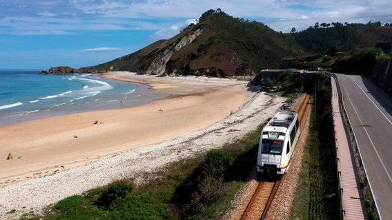 Die FEVE schlängelt sich dicht an der Küste Nordspaniens, nur ein paar Meter entfernt der Playa de San Antolín. © NDR/elb motion pictures GmbH/Felix Korfmann 