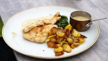 Cod served on a plate with fries and spinach.  © NDR 