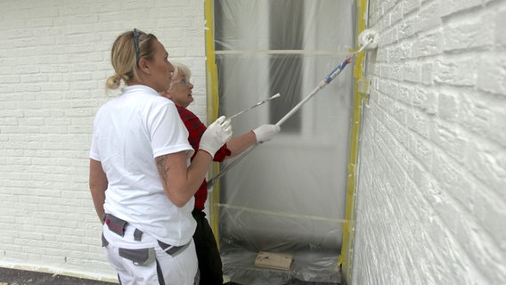 Zwei Frauen streichen eine Hausfassade. © NDR/nonfictionplanet 
