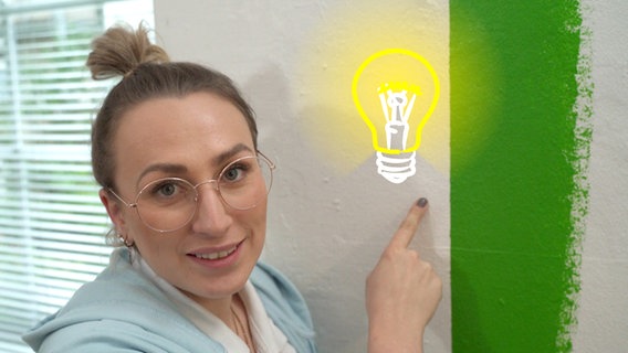 Nina zeigt auf die Malkante an der Wand © NDR/nonfictionplanet 