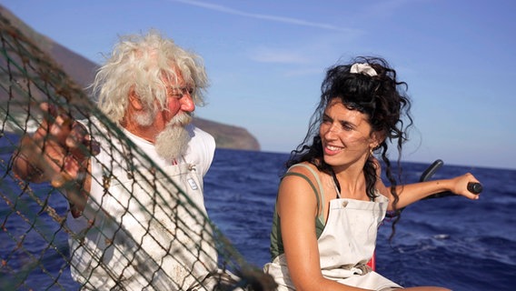 Ein älterer Mann und eine junge Frau sitzen auf einem Fischerboot. © NDR/nonfictionplanet/Florian Melzer, honorarfrei Foto: Florian Melzer