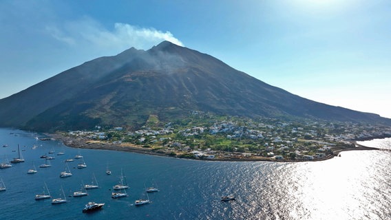 Blick auf eine Insel mit einem rauchenden Vulkan. © NDR/nonfictionplanet/Florian Melzer, honorarfrei Foto: Florian Melzer