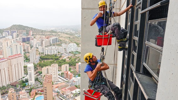 Kaffeepause am Seil. Die Fenster der Hochhäuser in Benidorm werden von Industriekletterern in schwindelerregender Höhe gereinigt. Nirgendwo in Europa gibt es so viele Wolkenkratzer pro Quadratkilometer wie hier. © NDR/nonfictionplanet/Manfred Uhlig 