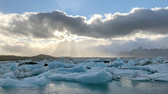 Eisige Lagune: Jökulsárlón, auf deutsch "Gletscherflusslagune", ist ein riesiger Gletschersee im Vatnajökull-Nationalpark. Hier brechen Eisbrocken vom Gletscher ab, schwimmen als blauschimmernde Eisberge einige Jahre in der Lagune, bevor sie immer kleiner werden, hinaus ins Meer treiben und schließlich ganz schmelzen. Mit 284 Metern ist Jökulsárlón der tiefste See Islands. © NDR/nonfictionplanet/Annette Plomin 