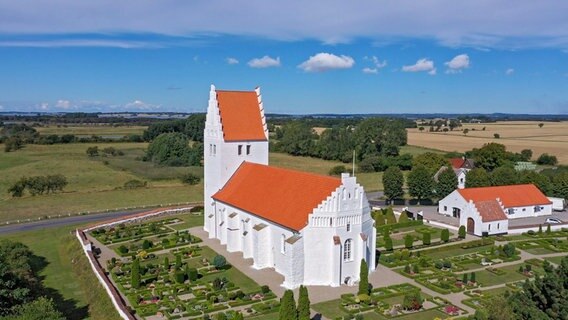 Kirche über der Küste: Die Fanefjord Kirche im äußeren Westen der Insel wurde im Mittelalter gebaut und ist für ihre Fresken berühmt: Der "Elmelunde-Meister" hinterließ im Kirchenschiff weit über die Inselgrenzen hinaus bekannte Kalkmalereien. © NDR/Florian Melzer 
