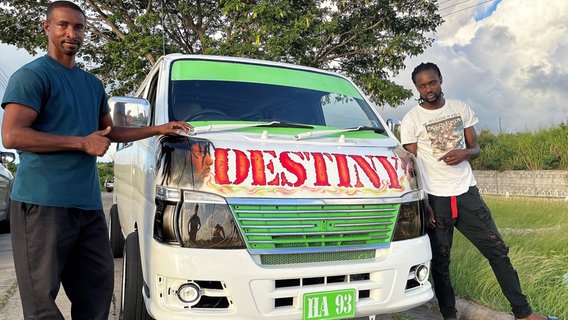 Rollende Kunstwerke: Der Spray-Painter Randy Thomas (rechts) gestaltet das Taxi seines Kumpels Alphonso Browne gerade neu - auf Wunsch mit einem Porträt des jamaikanischen Reggae Sängers Buju Banton. © NDR/nonfictionplanet/Steffen Schneider 