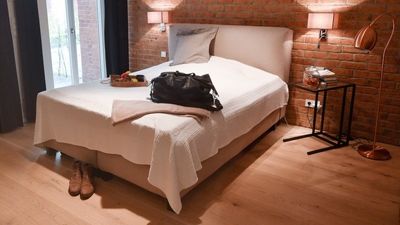Eine Reisetasche ist in der Wohnung eines Airbnb-Gastgebers auf dem Bett abgestellt © picture alliance / Jens Kalaene/dpa-Zentralbild/dpa Foto: Jens Kalaene