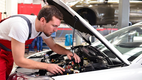 Ein Automechaniker in einer Werkstatt repariert ein Fahrzeug. © fotolia.com Foto: industrieblick