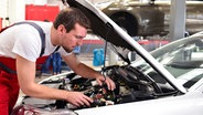 Ein Automechaniker in einer Werkstatt repariert ein Fahrzeug. © fotolia.com Foto: industrieblick