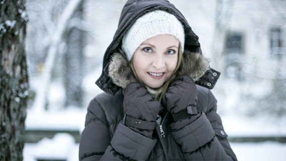 Frau im Schnee mit einer Daunenjacke. © Peter Atkins/fotolia Foto: Peter Atkins