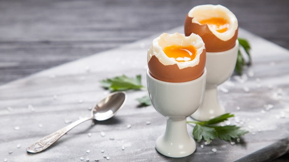Zwei weichgekochte, geöffnete Eier in Eierbechern. © Fotolia.com Foto: George Dolgikh