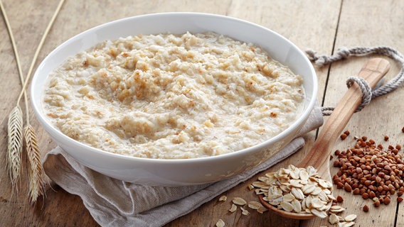 A plate of oatmeal and loose rolled oats on a wooden spoon © Colourbox Photo: -