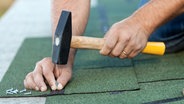 Mann schlägt Nägel mit einem Hammer in Dachpappe. © Arpad Nagy-Bagoly/fotolia Foto: Arpad Nagy-Bagoly