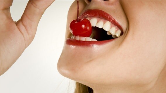 A woman bites into a cherry © Fotolia Photo: Taylor Hutchens