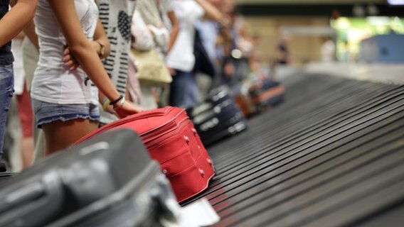 Fluggäste warten am Flughafen am Kofferlaufband. © fotolia/Brian Jackson Foto: Brian Jackson