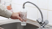 Männerhand hält ein Wasserglas unter einen Wasserhahn. © science photo/fotolia Foto: science photo
