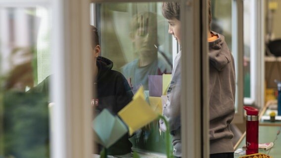 Schulkinder stehen an den geöffneten Fenstern ihres Klassenraumes © picture alliance/KEYSTONE Foto: ALESSANDRO DELLA VALLE