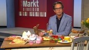 Markt Moderator Jo Hiller sitzt an einem österlich geschmückten Tisch. © NDR Foto: NDR