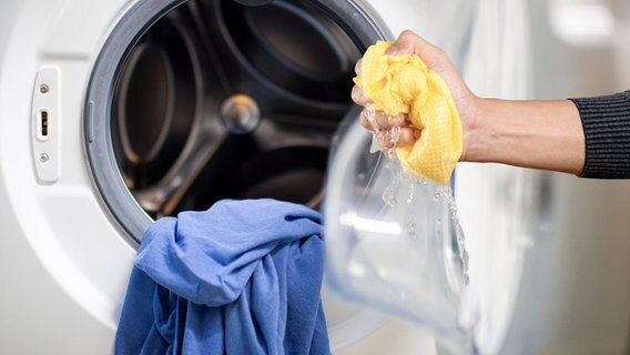 Aus einer Waschmaschine ausgelaufenes Wasser wird aufgewischt. © Imago Foto: Imago