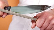 Ein Messer wird geschärft. © Fotolia.com Foto: Constantinos