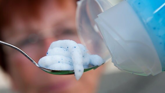Eine Kosmetikprodukt mit Mikroplastik (blaue Perlen) auf einem Löffel. © picture alliance / dpa Foto: Stefan Sauer